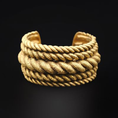 un gros plan d'un bracelet en chaîne dorée sur fond noir