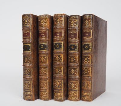 a set of four antique leather books on a white background