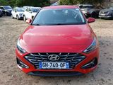the front of a red car parked in a parking lot