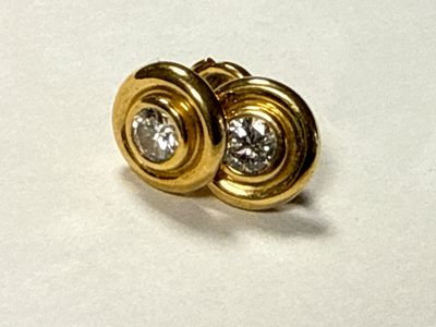 a pair of gold and diamond earrings on top of a piece of paper