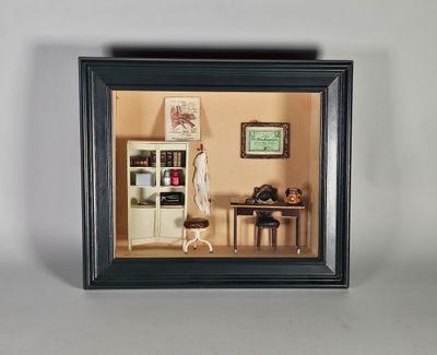une photo d'une maison de poupées miniature dans un cadre noir