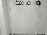 a white rack with clothes hanging on it in a room