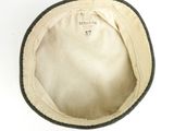 an old white hat with a black band on a white surface