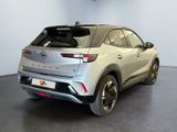 the rear end of a silver car in a showroom