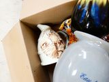 a box full of vases that are sitting on the floor