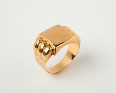 gros plan d'une bague en or sur une surface blanche
