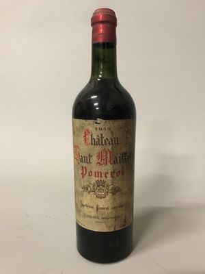 une bouteille de vin rouge posée sur une table blanche