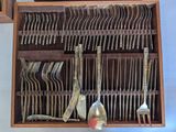 a lot of spoons and forks in a wooden box