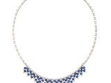a close up of a necklace with blue stones on a white background