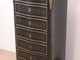 a black and gold chest of drawers on a wooden floor