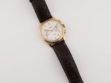 a close up of a watch on a white surface