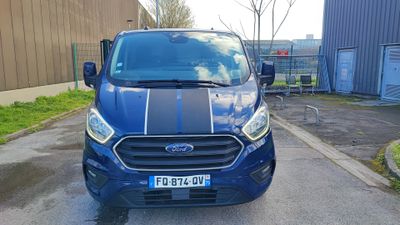 the front of a blue ford transit van parked in a parking lot