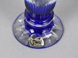 a blue glass vase with a gold plate on it