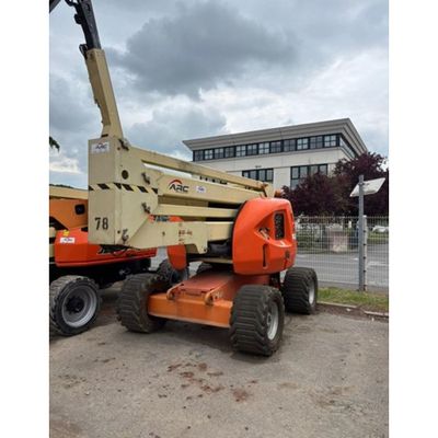 Une grue est garée devant un immeuble par temps nuageux.