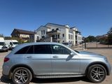 a silver mercedes suv parked in a parking lot next to a building