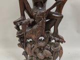 an image of a statue of a man sitting on top of a wooden chair