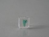 un petit morceau de verre contenant un cadran vert