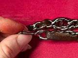 a person that is holding a chain on a pink surface