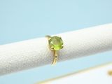 a close up of a ring with a green stone on it