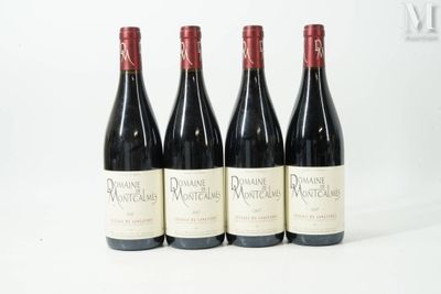 quatre bouteilles de vin sont alignées sur une surface blanche