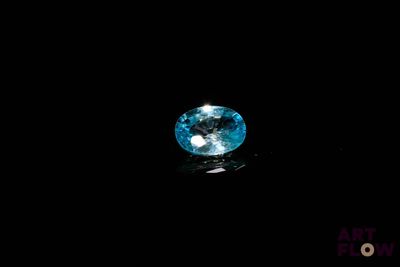 a close up of a blue diamond on a black surface
