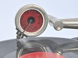 a silver record with a red clock on it
