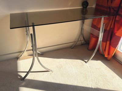 a glass table with a glass top sitting in front of a window
