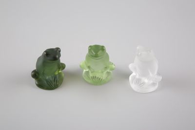 trois figurines en verre représentant une grenouille et un petit têtard