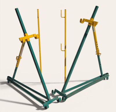trois outils de chantier verts et jaunes posés sur une surface blanche