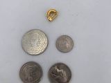 a close up of a coin and a small coin on a white surface