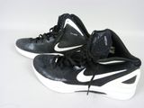 une paire de chaussures de basket Nike noires et blanches posées sur une surface blanche