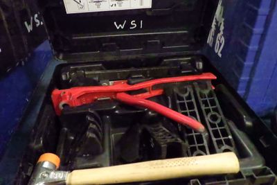 un outil dans une boîte à outils, à côté d'un marteau et d'une clé