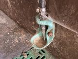 a metal grate with a green handle attached to it