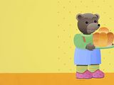 un ours de dessin animé tenant une miche de pain