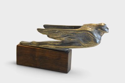 an image of a bronze bird statue on a wooden base