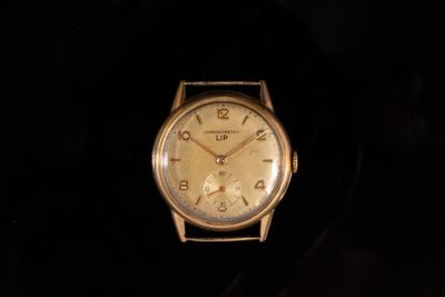 une image représentant une montre-bracelet en or sur fond noir