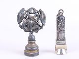 un petit objet en argent à côté d'un autre objet en argent, plus petit