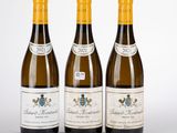 trois bouteilles de vin posées les unes à côté des autres sur une surface blanche