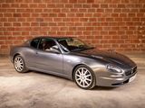a silver sports car parked in front of a brick wall