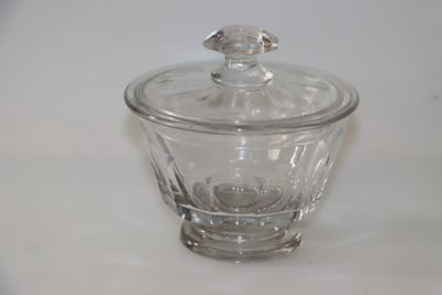 un bocal en verre muni d'un couvercle, posé sur une surface blanche
