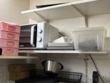 a microwave sitting on top of a shelf in a kitchen