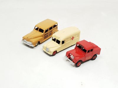 three toy cars sitting next to each other on a white surface