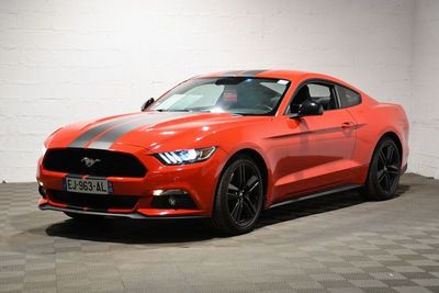 une Ford Mustang rouge garée dans un garage au sol carrelé