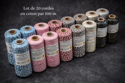 several spools of twine of different colors and sizes on a black background