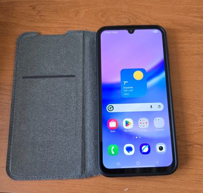 un gros plan d'un téléphone portable posé sur une table, à côté d'un portefeuille