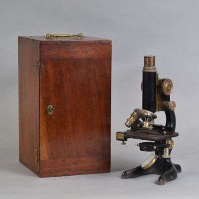 un vieux microscope avec une boîte en bois et une boîte en bois