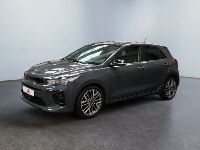 Une voiture grise est garée dans une pièce aux murs blancs.