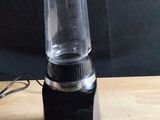 a blender sitting on a wooden table with a black background