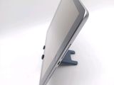 a tablet computer sitting on a stand on a white surface