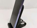 a close up of a cell phone on a stand on a table
